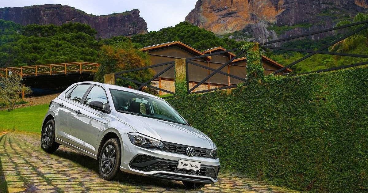 Volkswagen Polo Track 2023 cinza, de frente, estacionado em ladeira pavimentada com pedras, com cenário montanhoso ao fundo