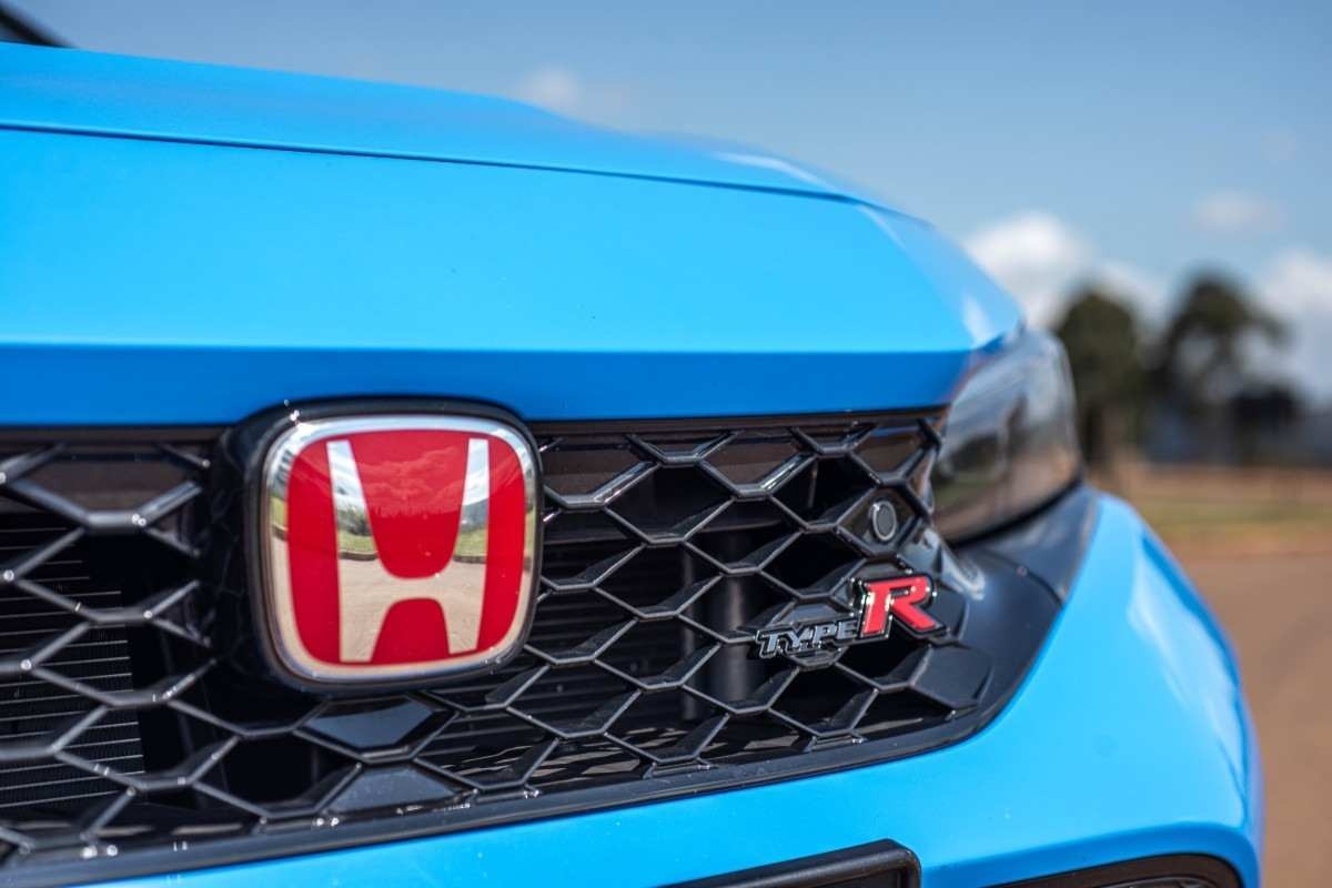 Honda Civic Type R modelo 2024 azul detalhe da grade dianteira e farol estático no asfalto