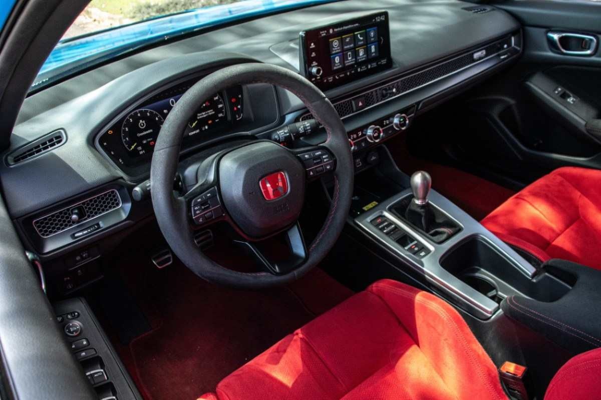 Honda Civic Type R modelo 2024 azul interior painel volante bancos dianteiros vermelhos estático no asfalto