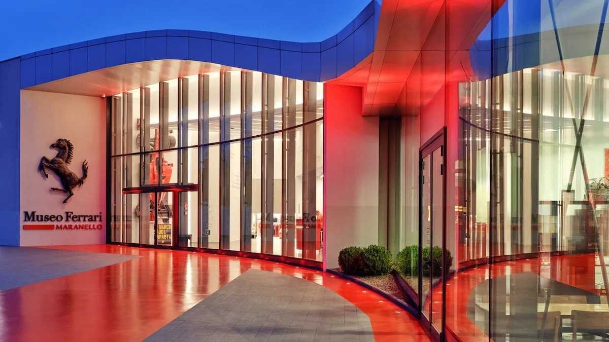 Entrada do Museu da Ferrari com vidraças e paredes vermelhas.