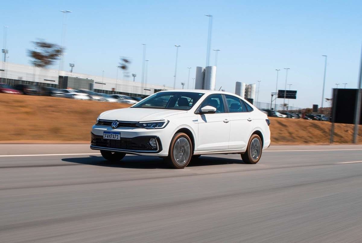 Volkswagen Virtus 200 TSI Highline 2024 branco de frente em movimento em rodovia asfaltada