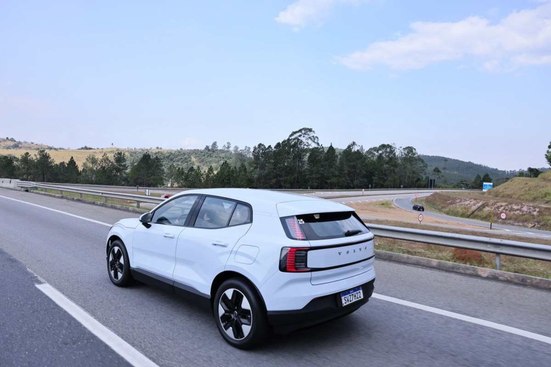 Volvo EX30 branco de traseira em movimento em estrada asfaltada