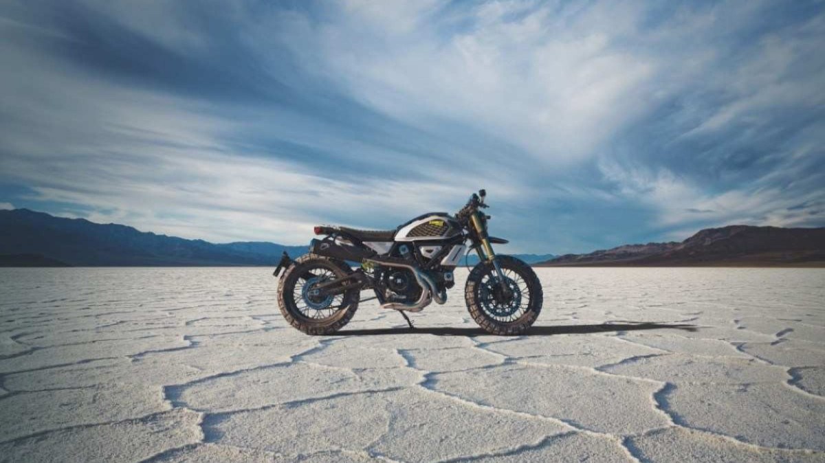 Ducati Scrambler RR 241 prata e preto com detalhes amarelos e dourados de lateral estática no deserto de sal