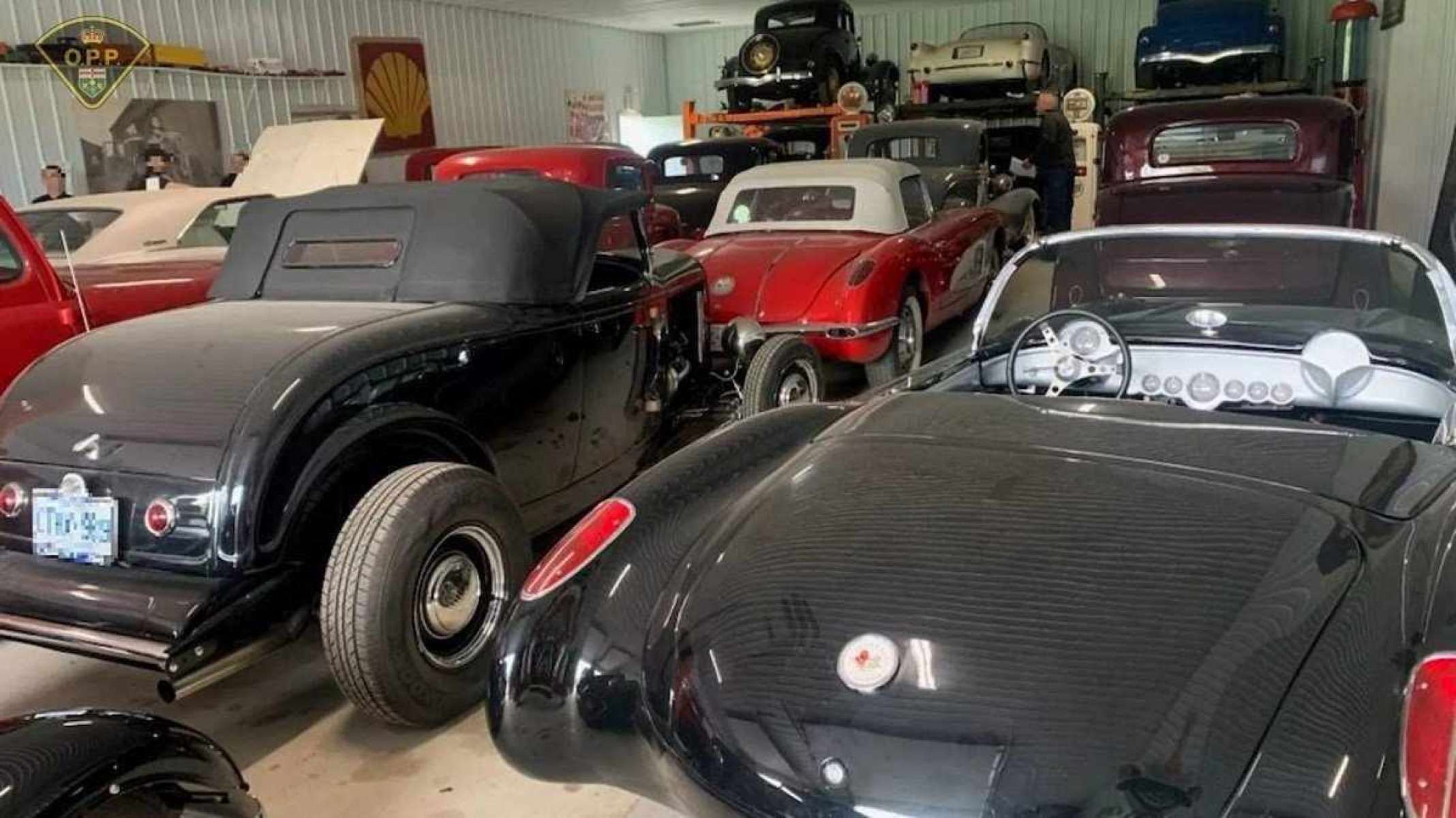Veículos pretos clássicos dentro de um celeiro.