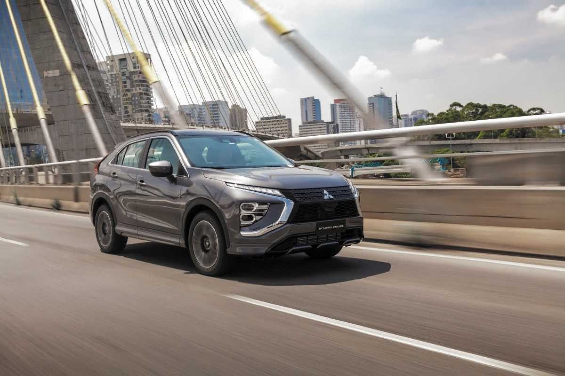 Mitsubishi Eclipse Cross HPE S modelo 2023 cinza de frente em movimento no asfalto passando sobre ponte em São Paulo