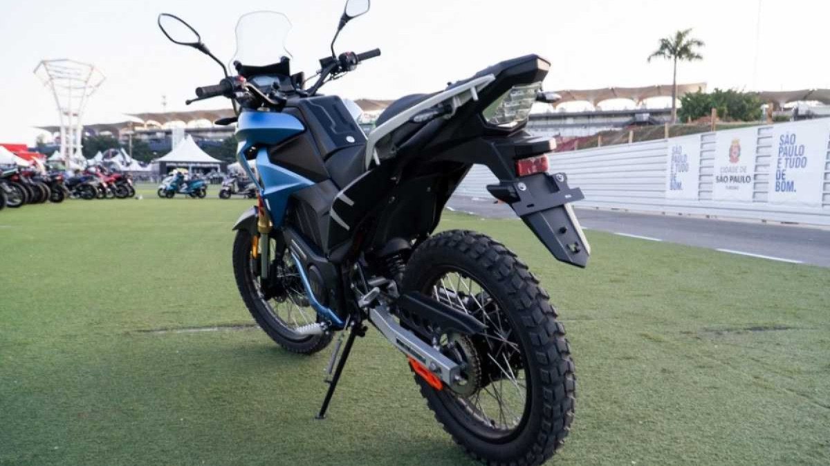 Motocicleta elétrica Watts W-Trail azul e preta modelo 2024 com traseira estática no gramado