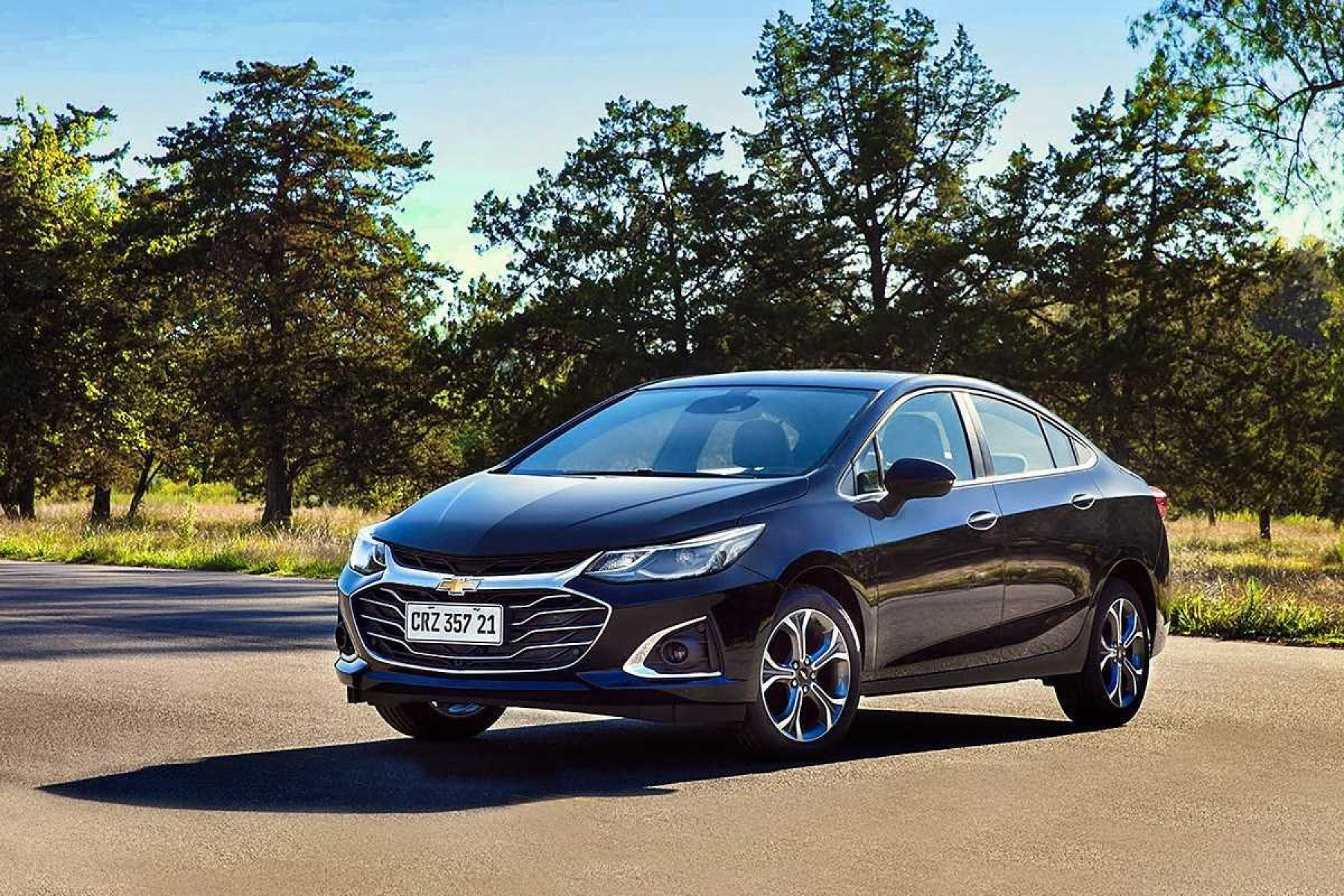 Chevrolet Cruze Premier 2021 preto, de frente, estacionado em local asfaltado, com árvores ao fundo