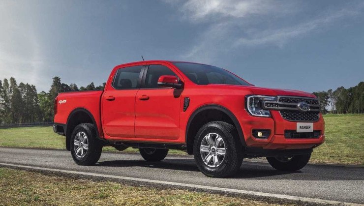 Ford Ranger XLS 2.0 turbodiesel 2024 vermelha, de frente, estacionada em local asfaltado, com gramado em primeiro plano