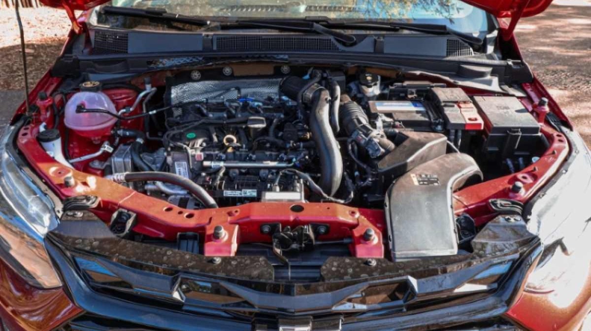 Chevrolet Onix RS modelo 2022 vermelho de frente cofre do motor turbo estático no asfalto