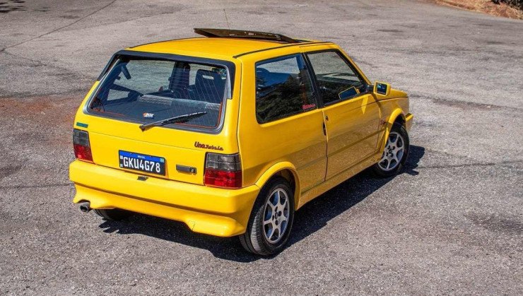 Fiat Uno Turbo 1994 amarelo, visto de traseira estacionado em local asfaltado