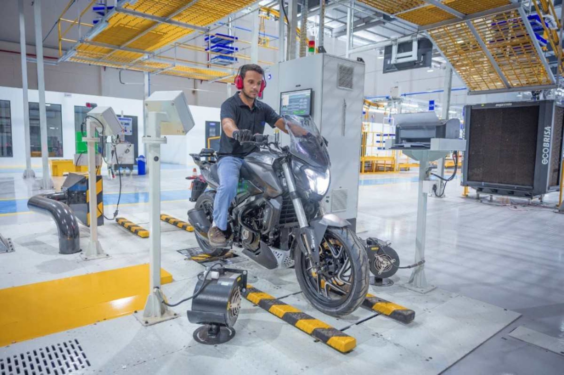 F&aacute;brica da Bajaj em Manaus Amazonas linha de montagem com moto Dominar 400 preta de frente no dinam&ocirc;metro dentro do galp&atilde;o