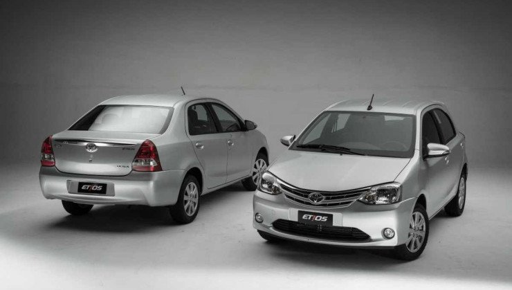 Toyota Etios Sedan prata de traseira e hatch prata de frente estáticos no estúdio