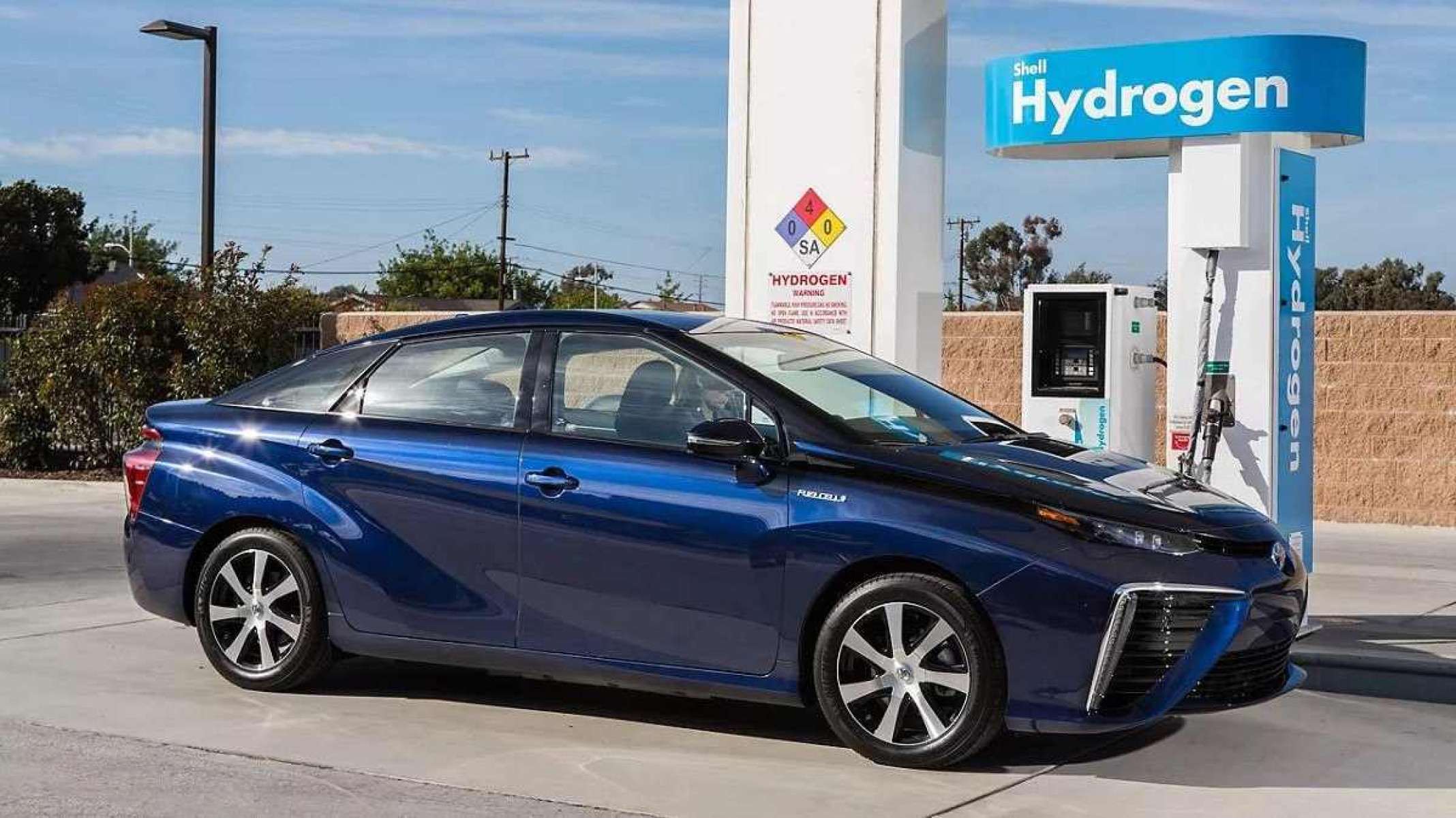 Toyota Mirai azul de lateral estático em postos de abastecimento