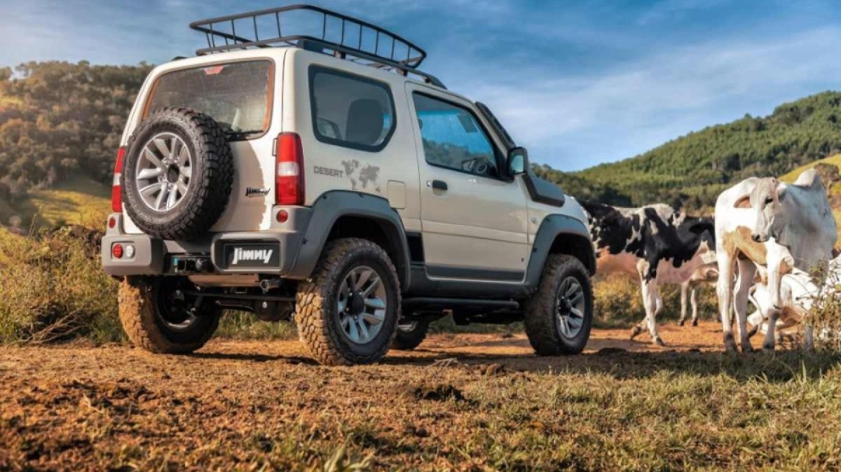 Suzuki Jimny 4x4 modelo 2019 versão Desert branco de traseira estático na terra com vacas ai lado