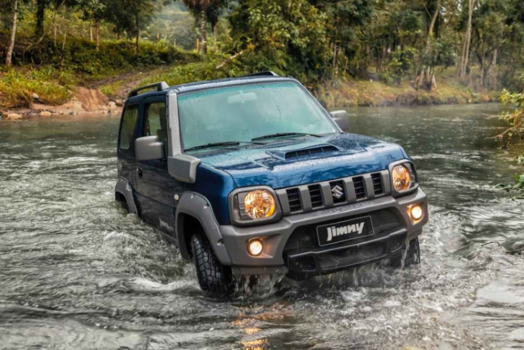 Suzuki Jimny 4x4 modelo 2019 azul de frente em movimento atravessando riacho