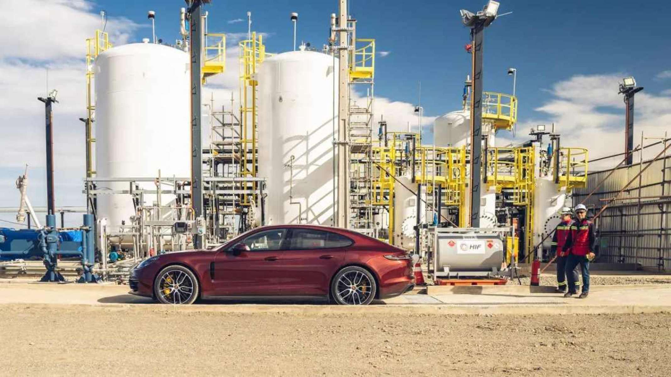 Carro vermelho parado em frente a equipamentos de produção de combustível sintético