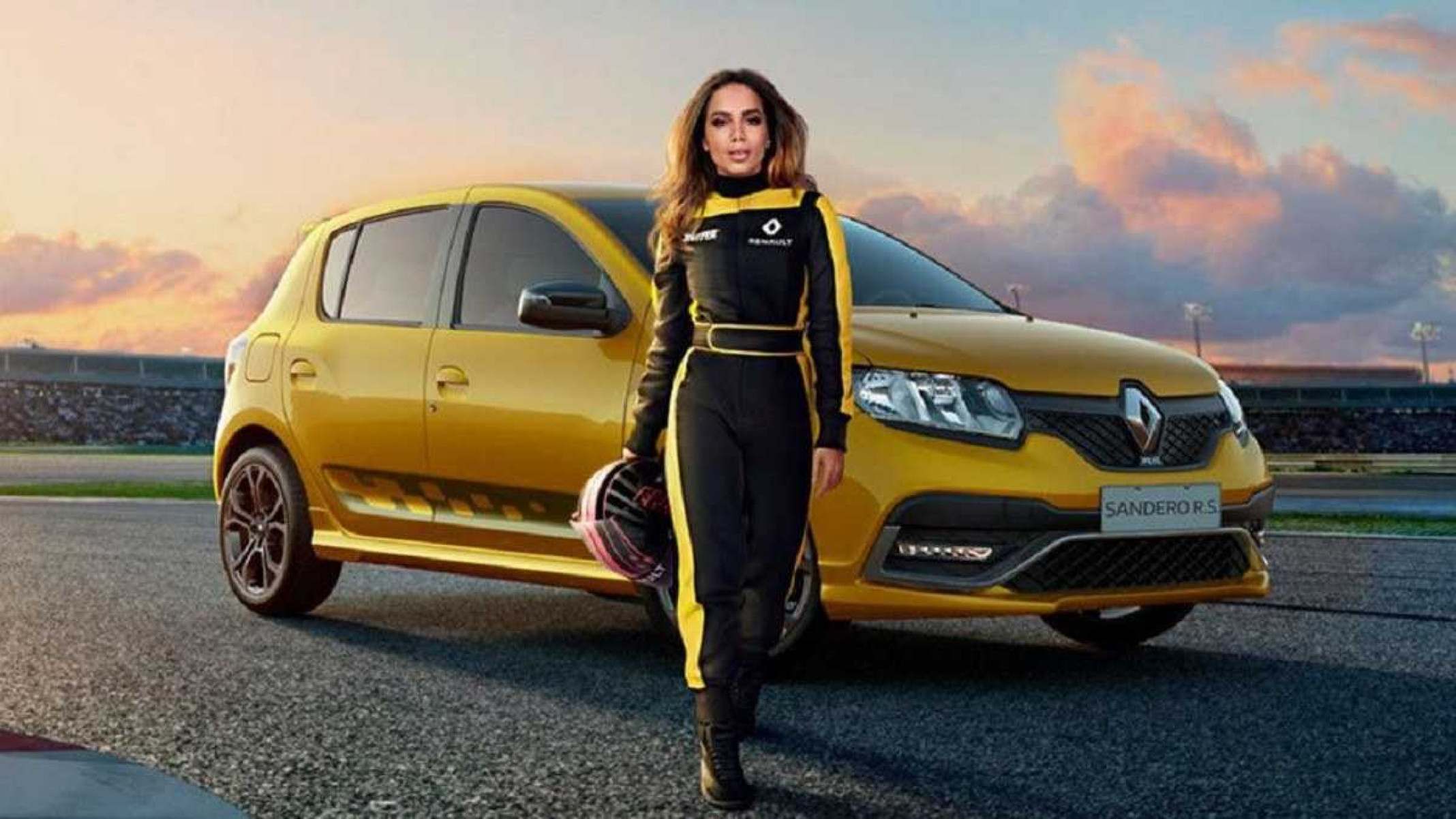 Anitta de macacão preto e amarelo segurando um capacete em frente ao Renault Sandero RS amarelo