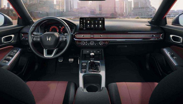O interior do Honda Civic Si painel volante multim&iacute;dia e bancos dianteiros com pr&eacute;dios na paisagem