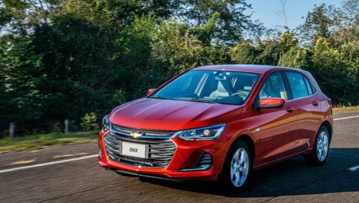 Chevrolet Onix 2020 Hatch vermelho, de frente, em movimento em via asfaltada