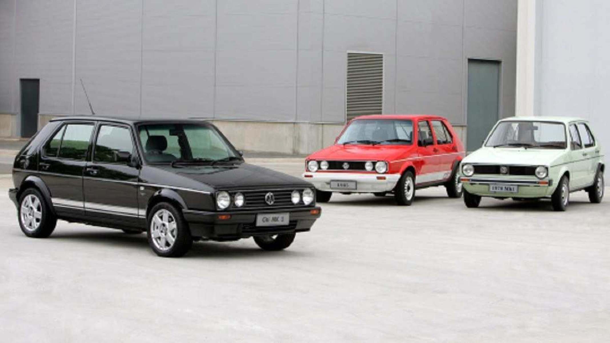 Três Volkswagens Golf Mk1 em preto, vermelho e amarelo parados de frente