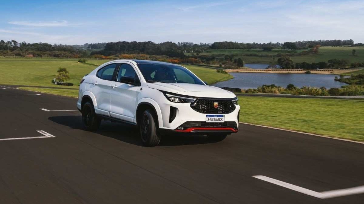 Fiat Fastback Abarth modelo 2023 branco com detalhes vermelhos de frente em movimento em pista asfaltada com gramado ao fundo