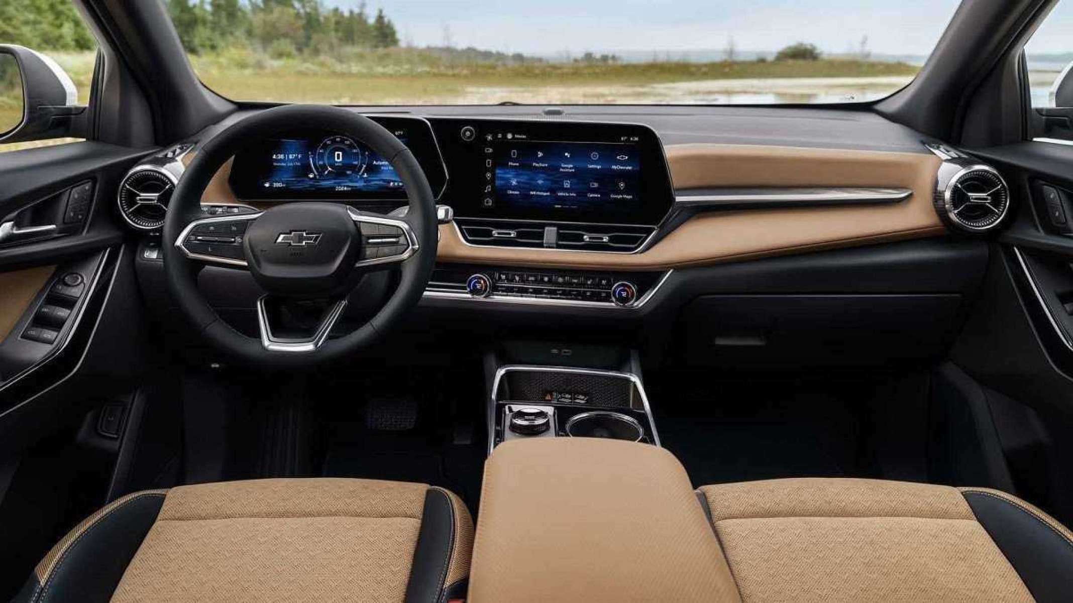 Interior do novo Chevrolet Equinox com acabamento em caramelho e detalhes pretos. Pelo para-brisa e janelas laterais é possível ver gramada com árvores de folhagem verde clara e céu ao fundo