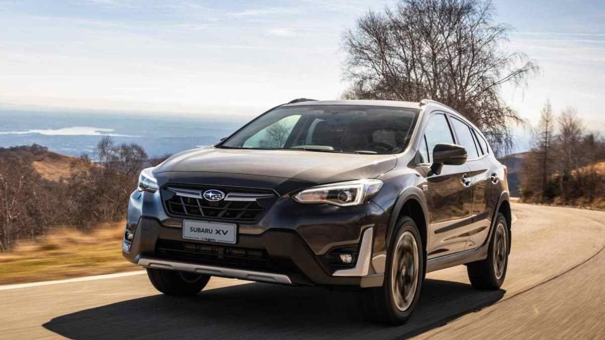 Subaru XV de frente, percorrendo uma sinuosa estrada de asfalto, com paisagem formada por montanhas ao fundo