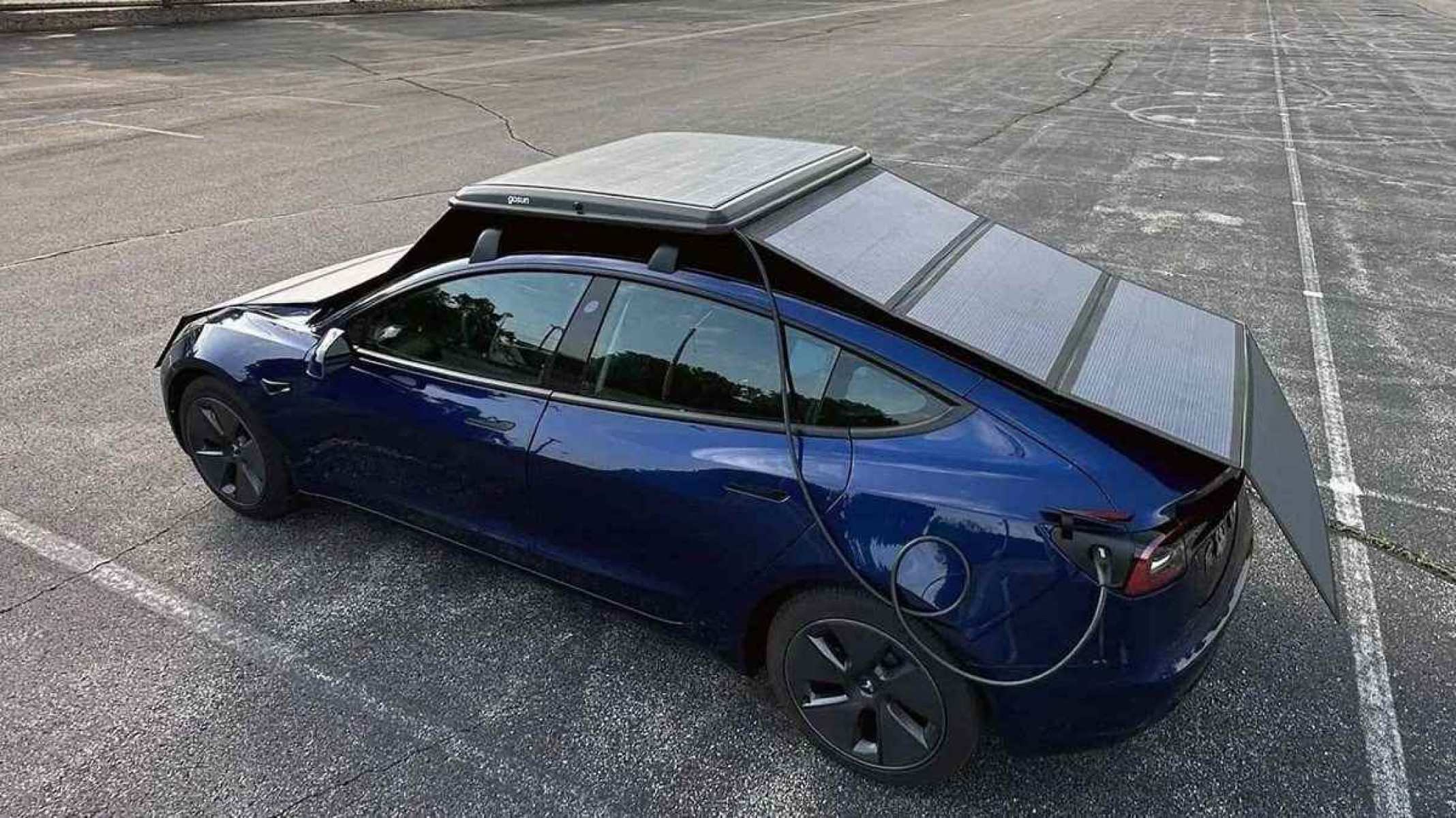 Carro elétrico azul escuro visto de cima por trás com painéis solares montados em sua carroceria