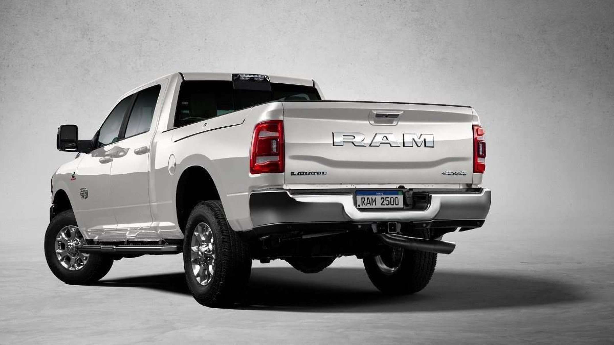 RAM 2500 Rodeo Edition vista de trás com detalhes no lado esquerdo. O veículo está estacionado sobre um fundo branco e sua sombra é projetada no canto inferior direito da imagem. 