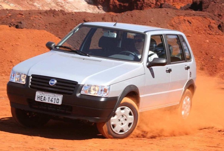 Fiat Uno Mille Fire Way 1.0 Flex modelo 2006 quatro portas prata de frente em movimento na terra