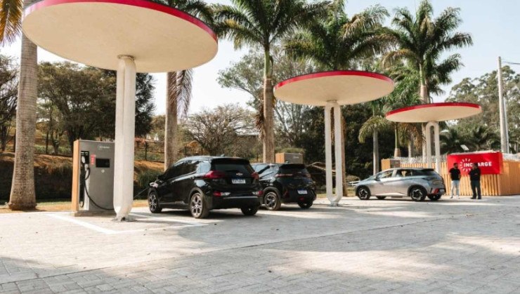 Eletroposto da Incharge na Rodovia Fern&atilde;o Dias Minas Gerais com tr&ecirc;s carros el&eacute;tricos fazendo a recarga das baterias enquanto motoristas aguardam em p&eacute;