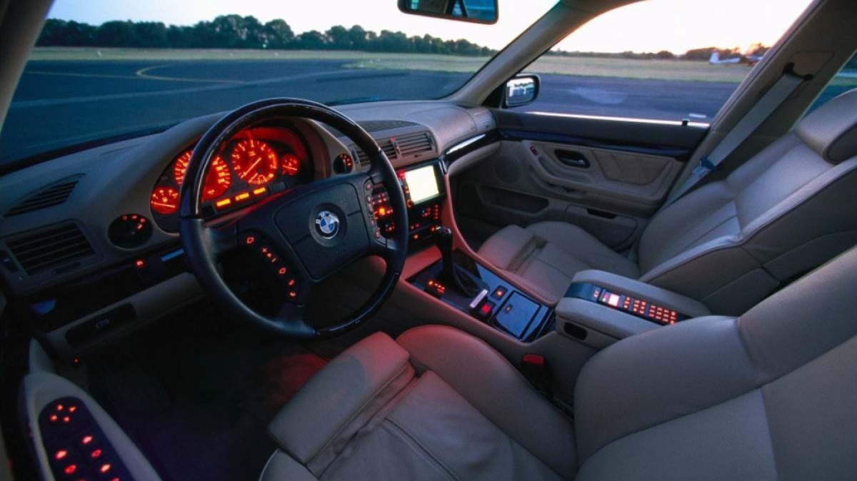 O interior do BMW 740i se destaca pelos bancos de couro, iluminação laranja e telefone