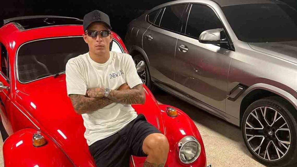 Guilherme Arana posando em frente ao seu Fusca, ao lado de BMW X6