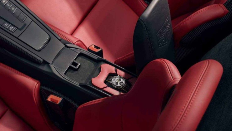 Interior do Porsche 718 Spyder na cor vermelha com destaque para compartimento para guardar o relógio comemorativo