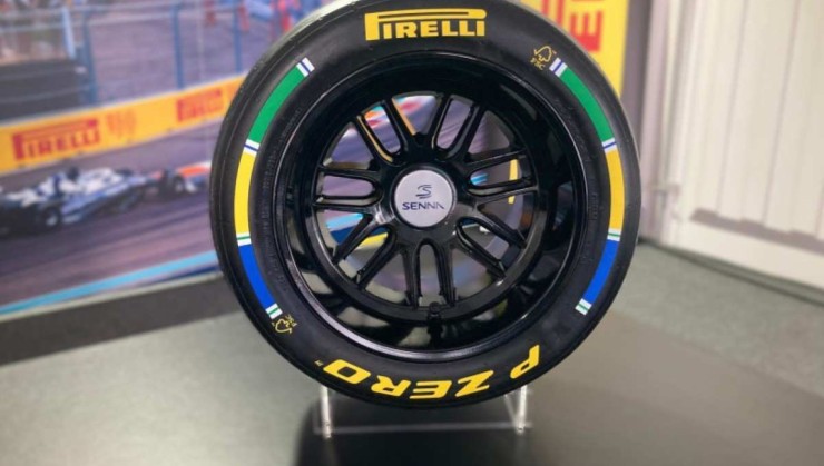 troféu de pneu Pirelli de Fórmula 1 com inscritos "Pirelli" e "P Zero" em amarelo e faixa nas cores azul, amarelo e verde nas laterais 