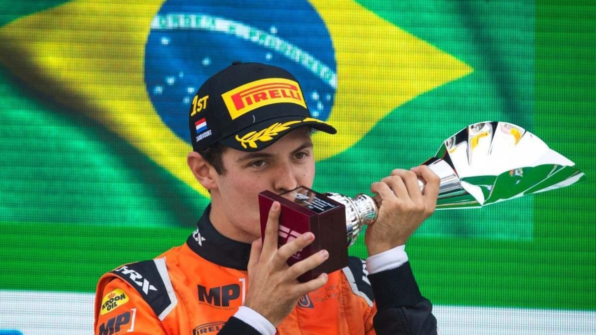 Felipe Drugovich, piloto reserva da Aston Martin, na Fórmula 1 beijando troféu após vitória