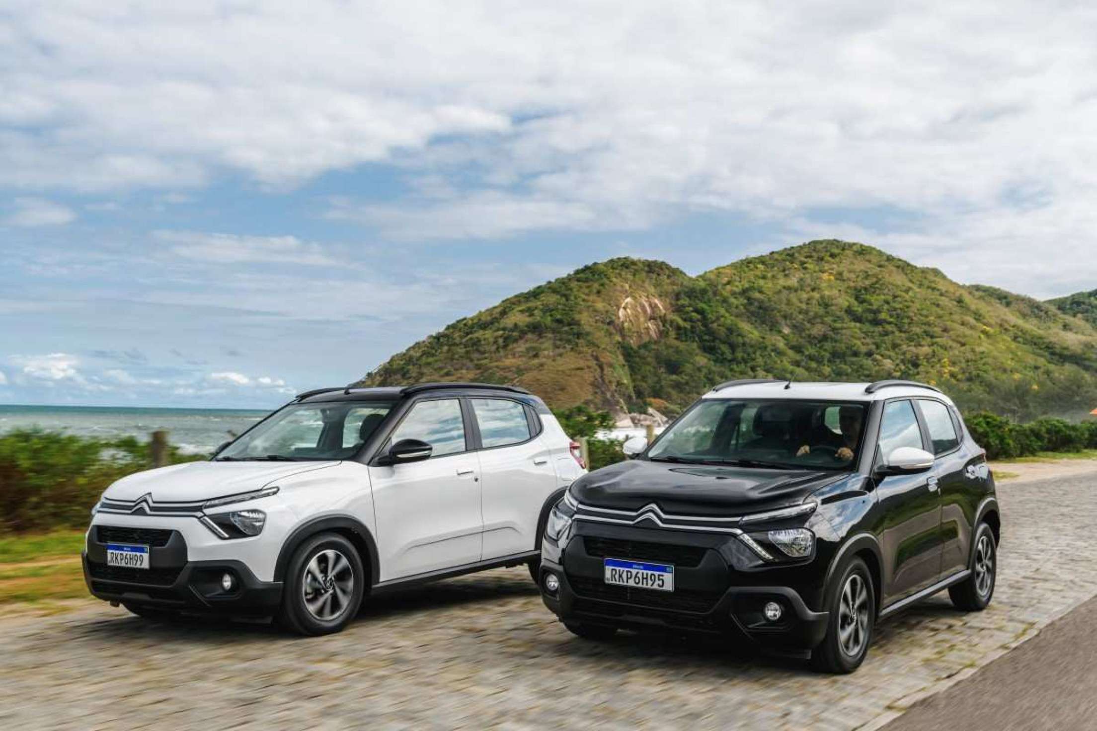 Dois hatches Citroën C3 estacionados nas cores preta e branca