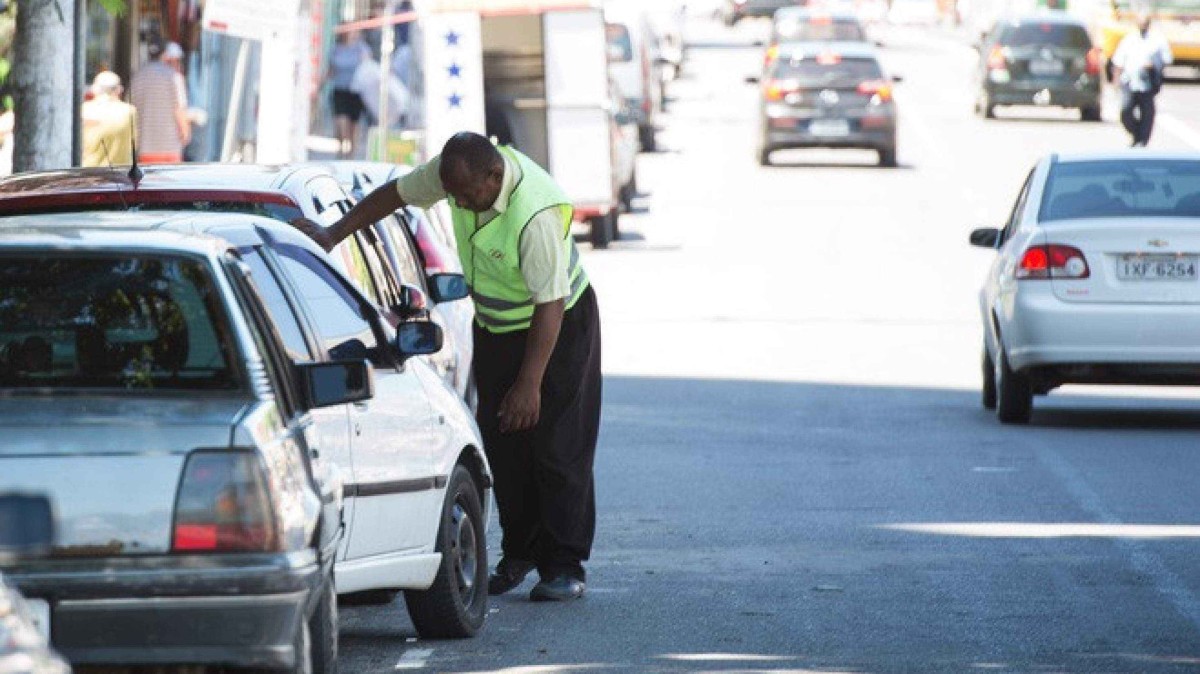 Homem com colete na rua aborda motorista dentro de carro