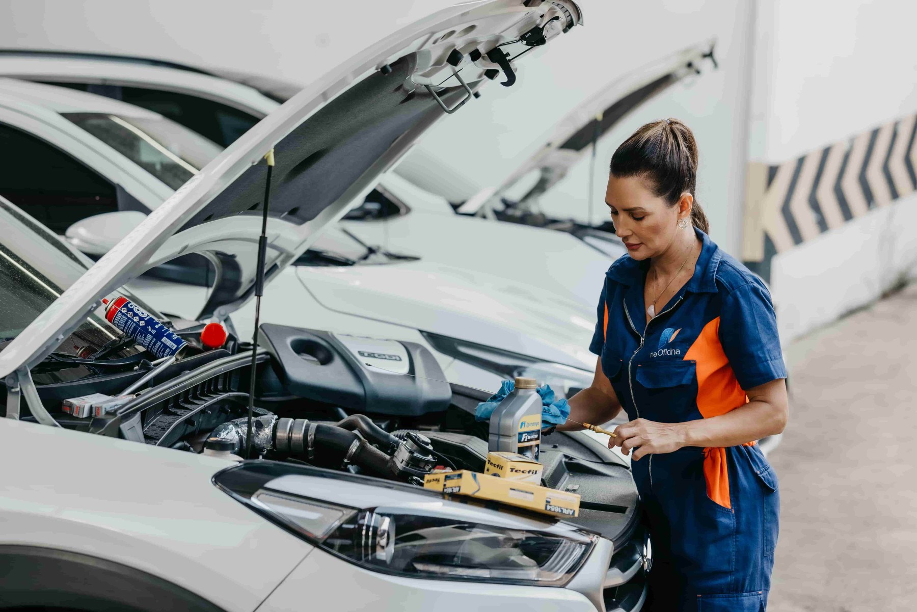 Mulher realizando manutenção em carro