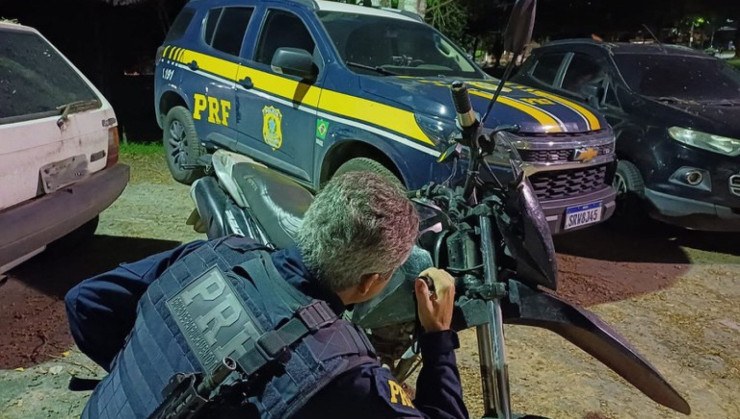 Policial Rodoviário Federal verificando os dados de uma motocicleta