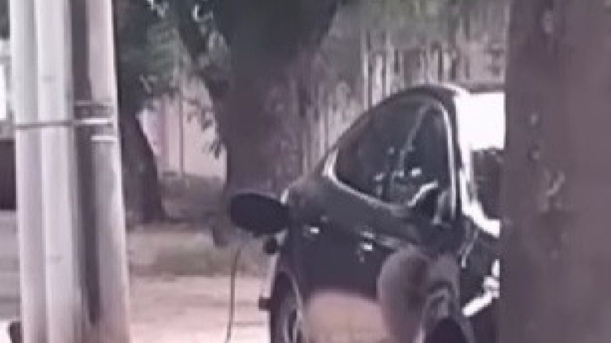 Homem carrega seu BYD King em poste de luz no Rio de Janeiro