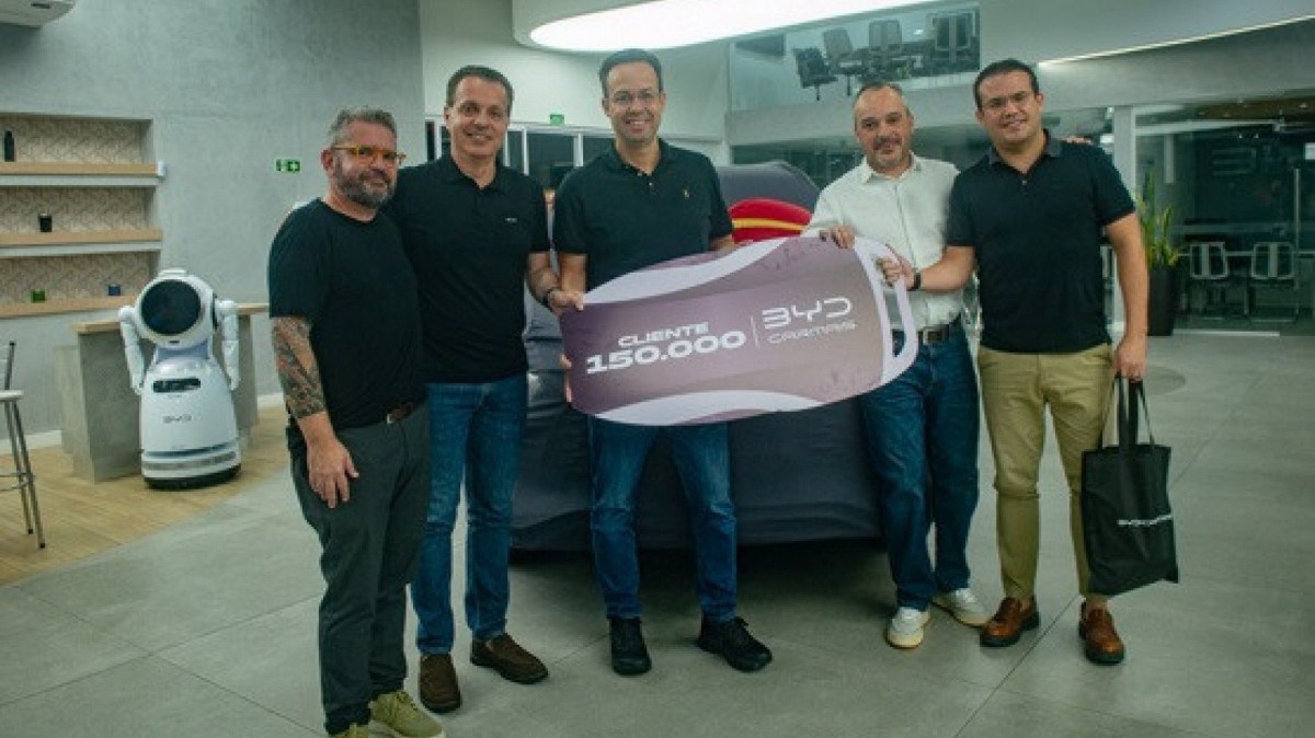 Funcionários da BYD entregam chave simbólica para cliente comprou o carro de número 150 mil da marca no país