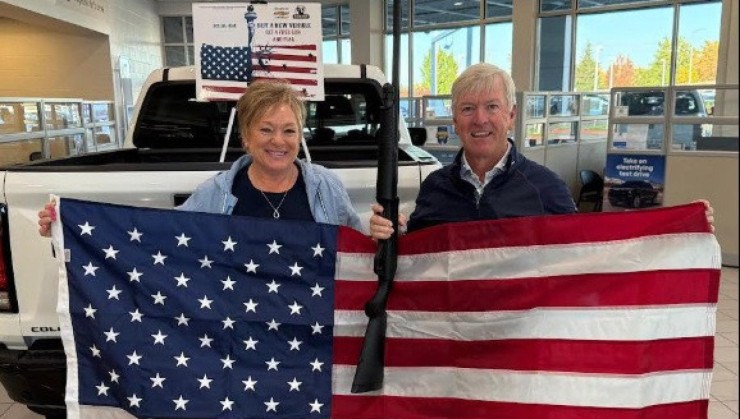 Moradores de Idaho, nos EUA, posam com bandeira dos EUA e espingarda após compra de carro 0 km da Chevrolet  -  (crédito: Reprodução/Facebook)