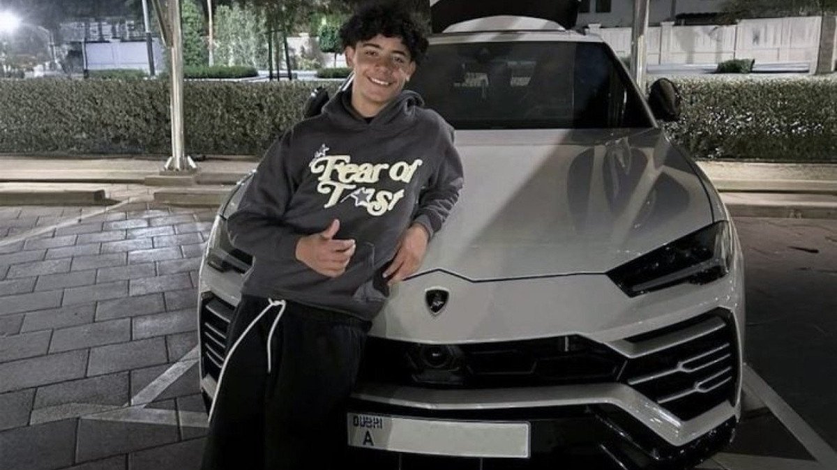 Cristiano Ronaldo Jr. posando ao lado de seu presente de aniversário de 15 anos