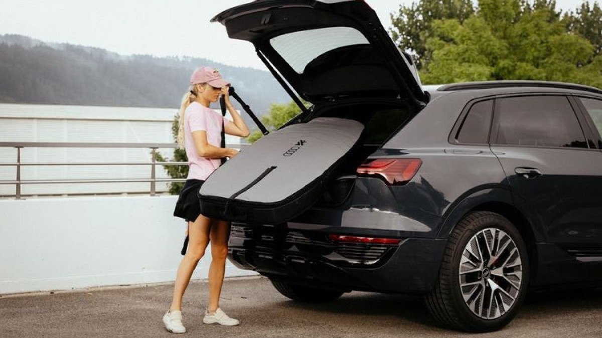 Mulher guarda seu Audi Aerofolis em porta-malas