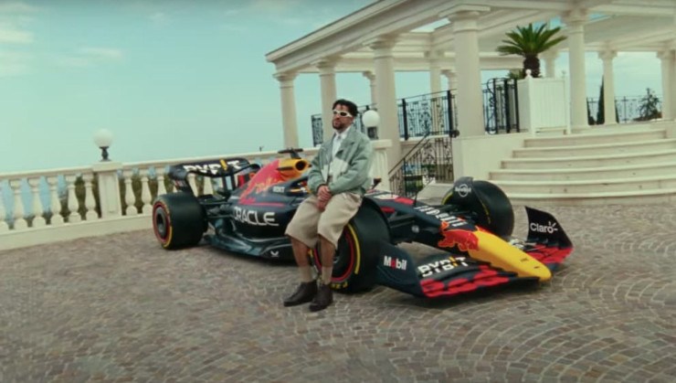 Bad Bunny ao lado de uma r&eacute;plica do carro de F&oacute;rmula 1 da Red Bull