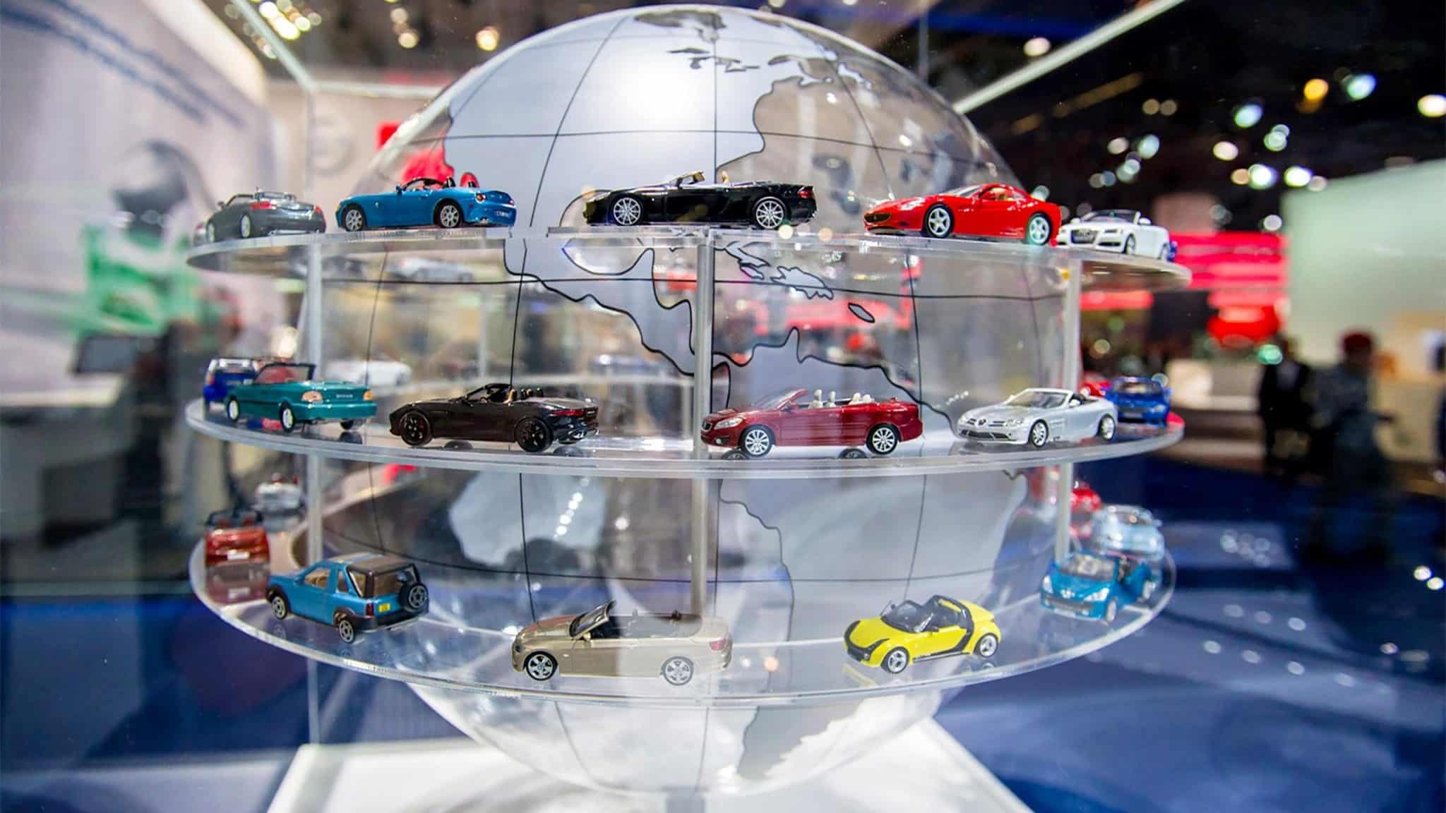 Modelos de carros em exposi&ccedil;&atilde;o sobre um globo simbolizam o mercado automotivo global, impulsionado pelas vendas de el&eacute;tricos na Europa -  (crédito: Divulga&ccedil;&atilde;o/ACEA)