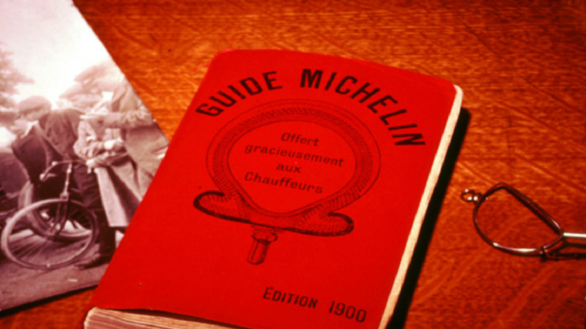 Guia Michelin de capa vermelha sobre mesa de madeira
