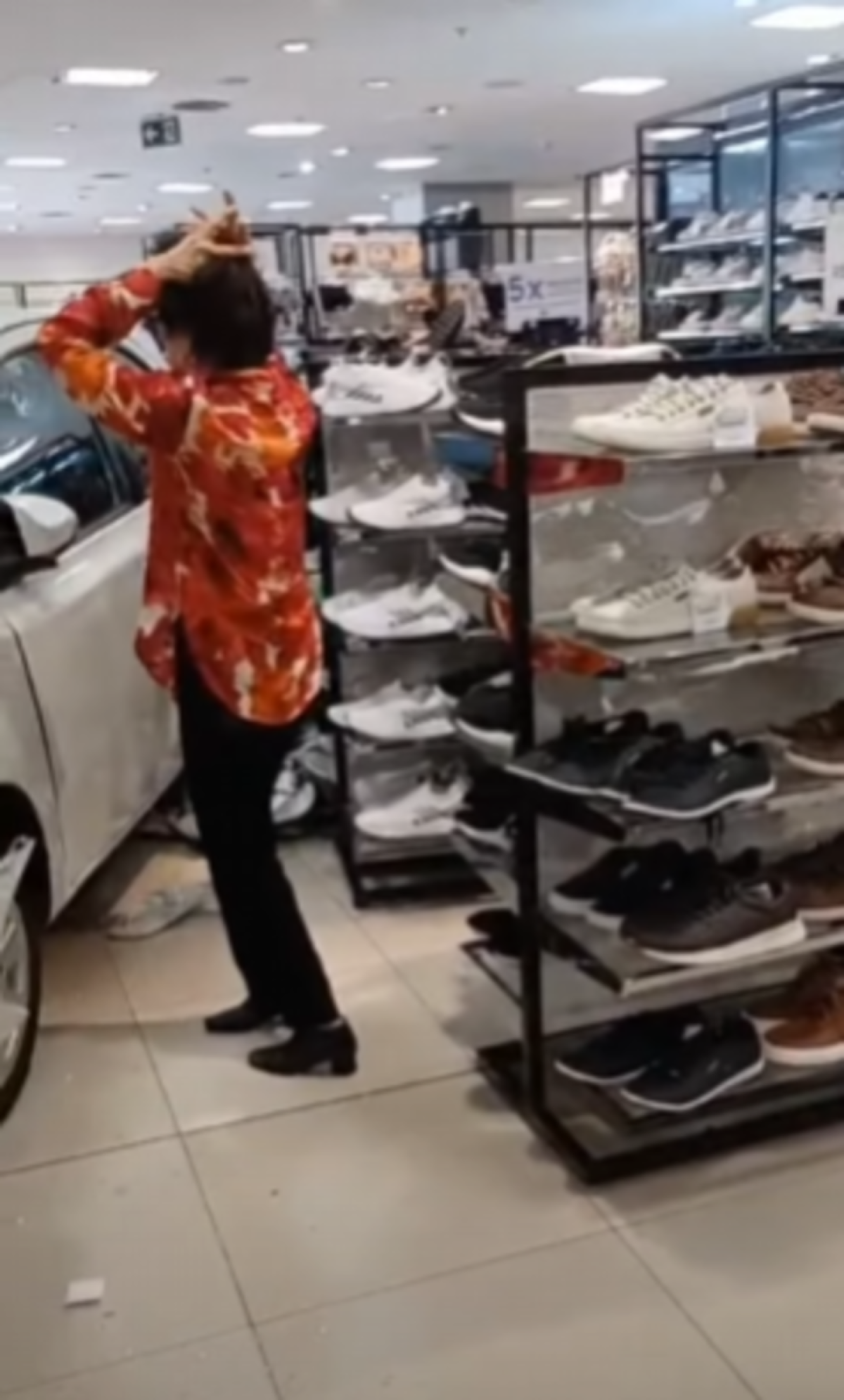 Dona de Toyota Etios que invadiu shopping desesperada, com as mãos sobrea a cabeça, em frente ao carro batido