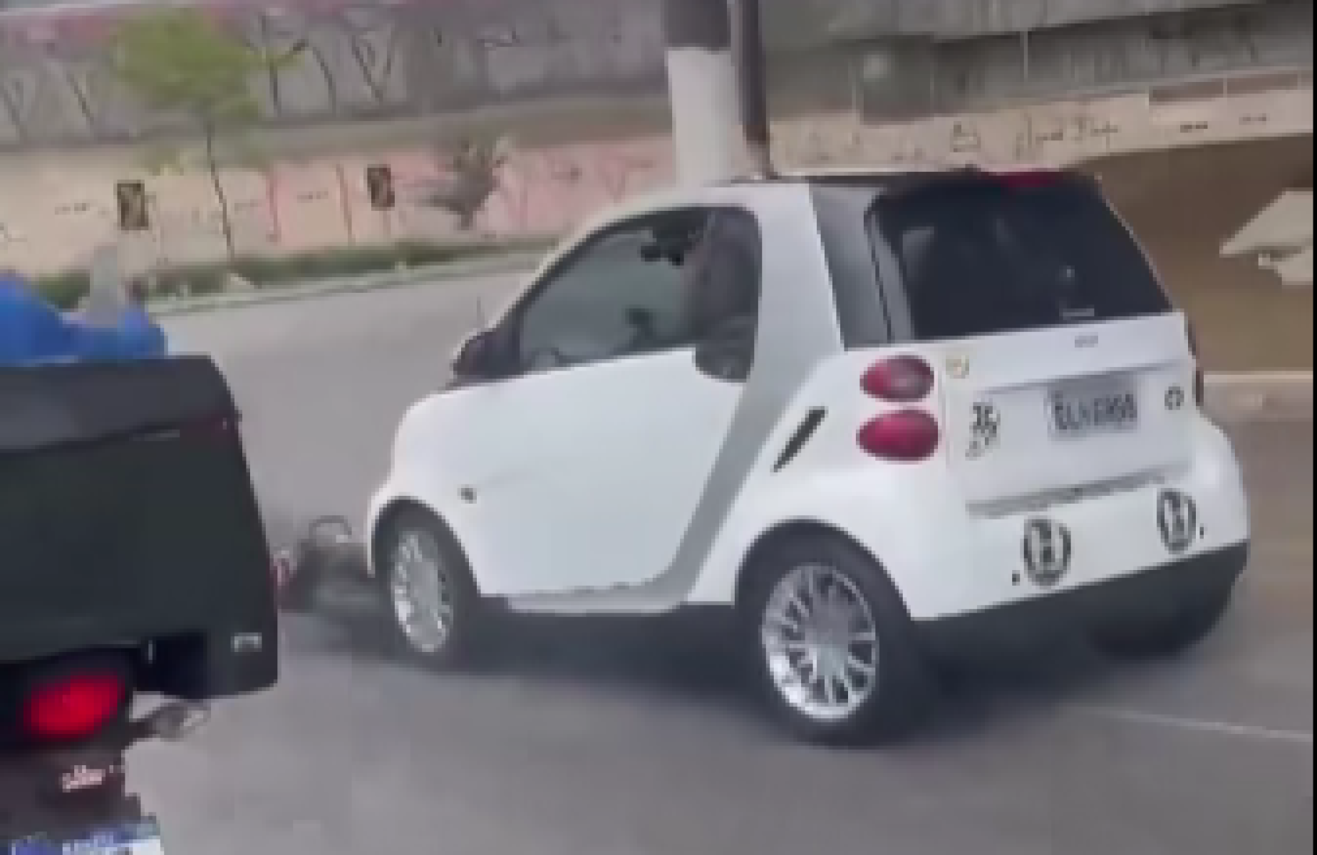 Carro branco arrasta motocicleta em agitada avenida de São Paulo